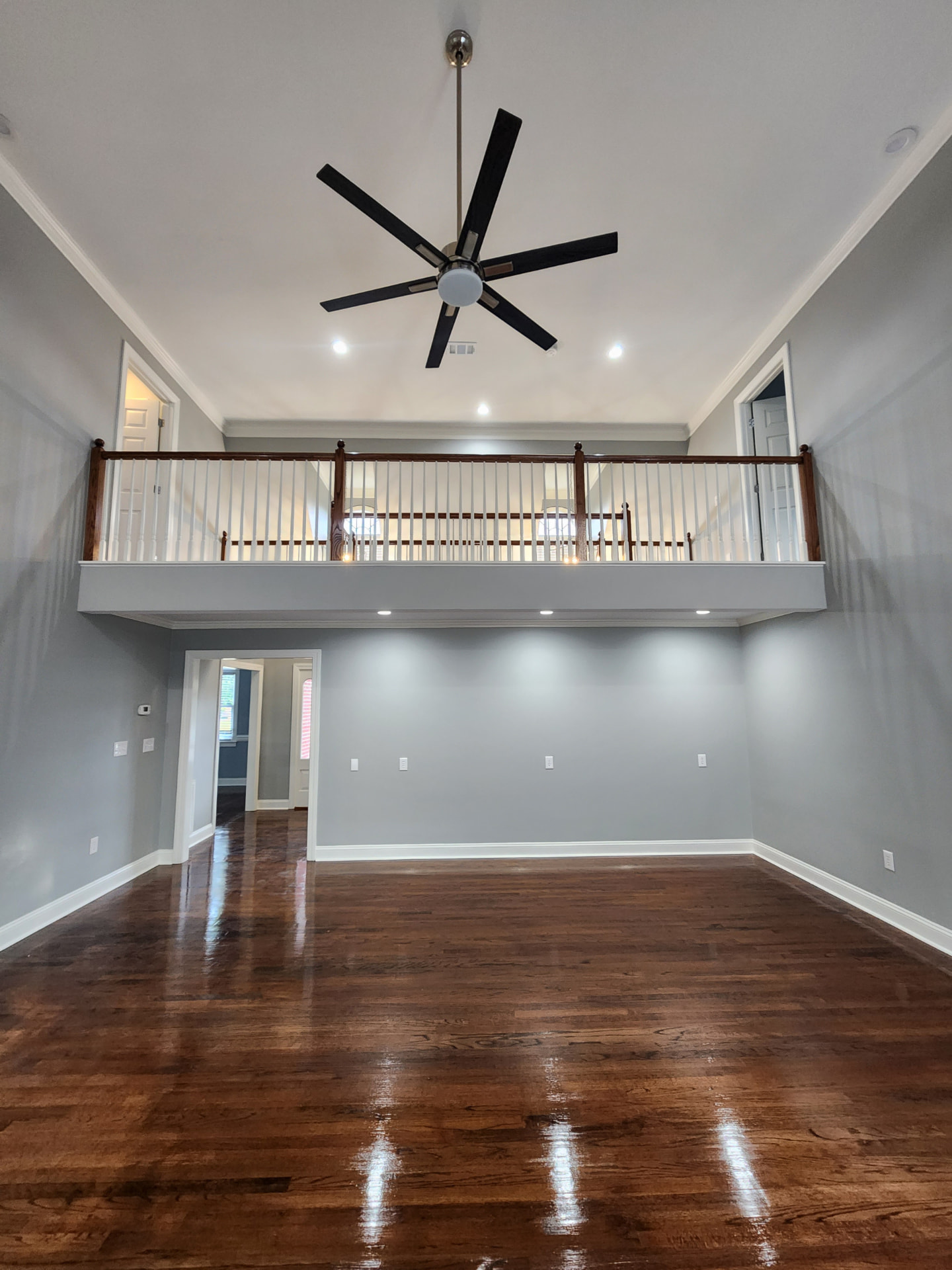 Two-story great room with fresh gray paint and refinished hardwood floors